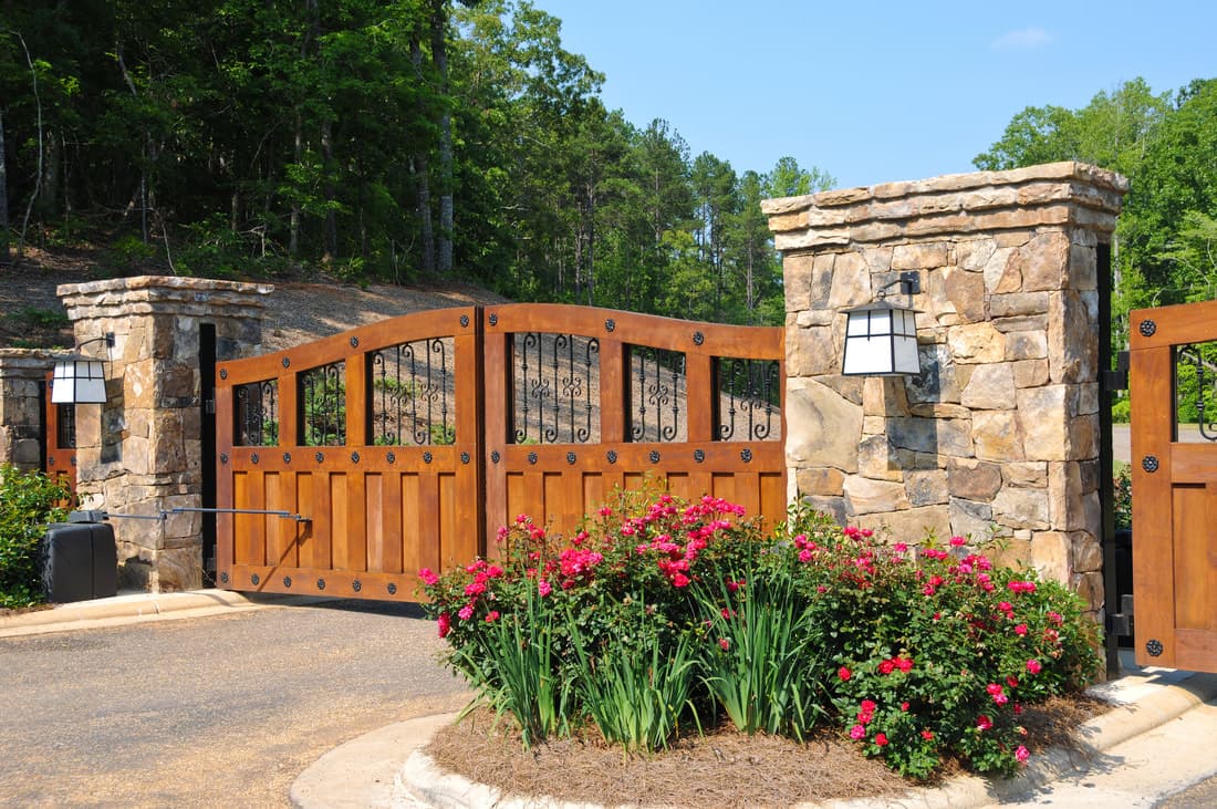 Wooden double driveway gate with iron inserts between stone pillars